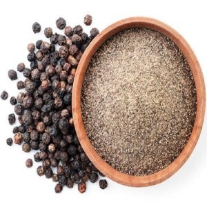 Ground black pepper in a wooden bowl and peppercorns close-up on a white background, isolated. Top view